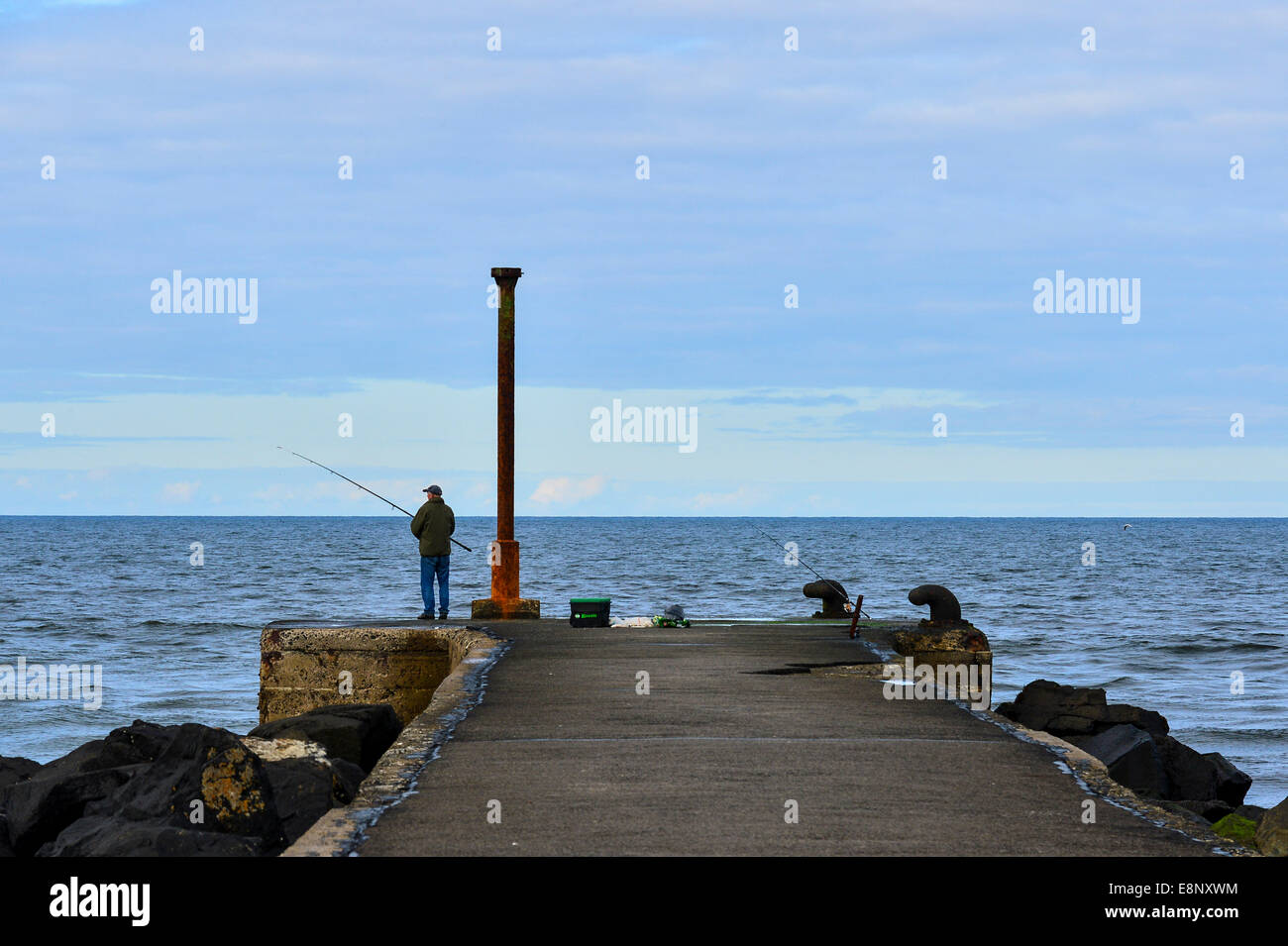 Contea di Londonderry, Irlanda del Nord, Regno Unito. Xii Ottobre 2014. Un uomo la pesca da Castlerock Pier, County Londonderry oggi nel tardo pomeriggio come il clima autunnale continua. Credito: George Sweeney/Alamy Live News. Foto Stock