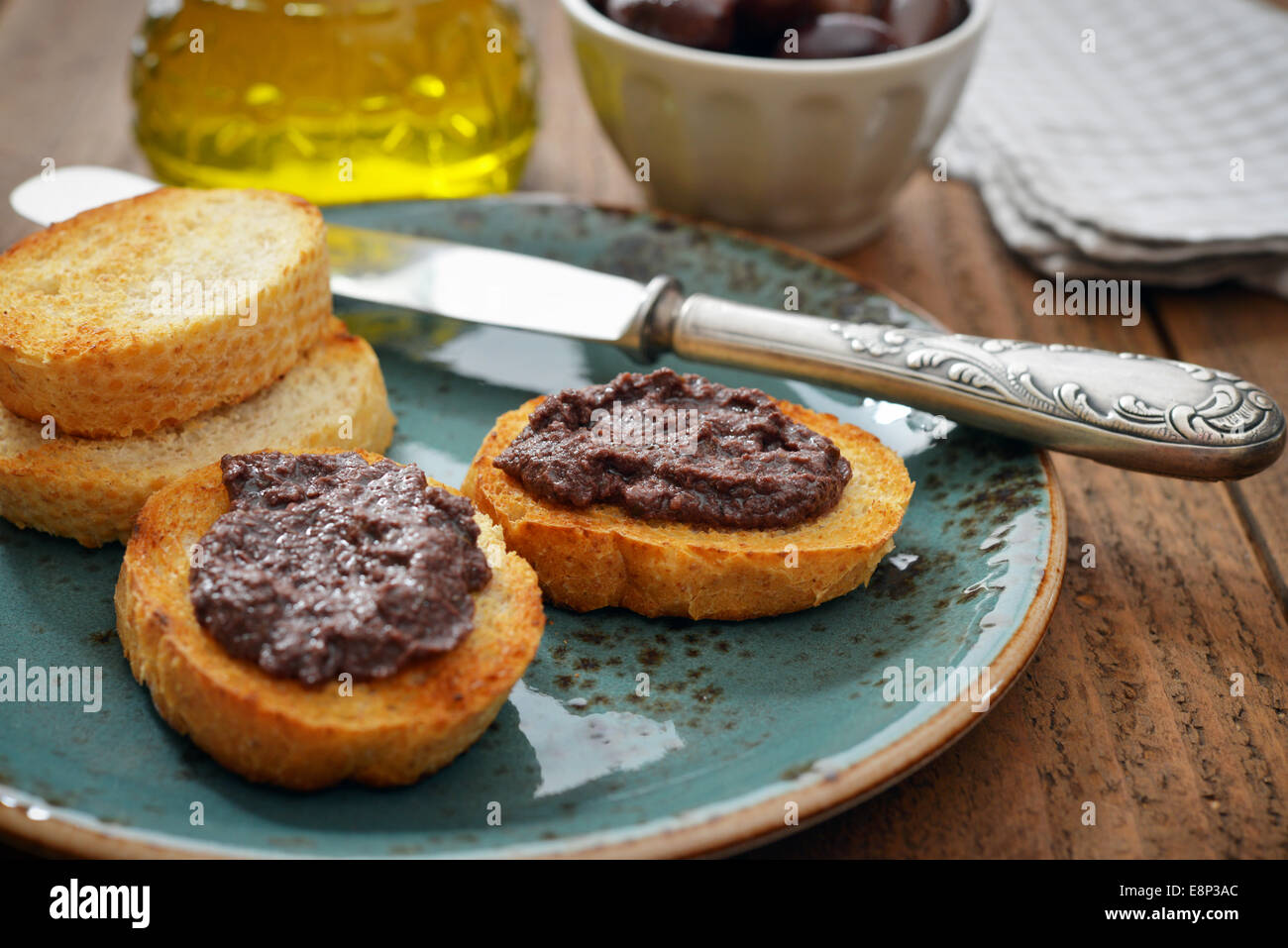 Pane con patè di olive su piastra in primo piano. La cucina greca Foto Stock