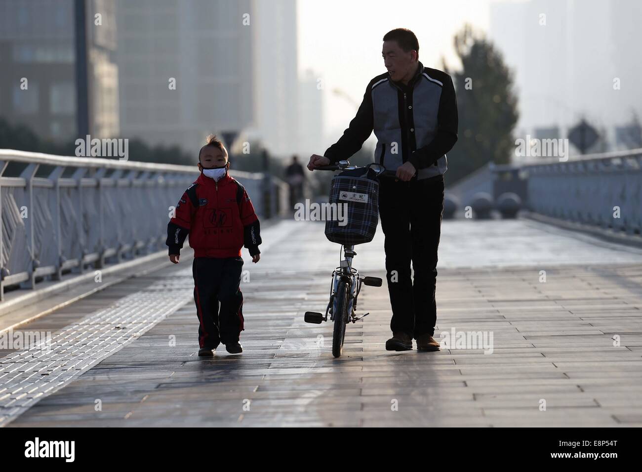 Taiyuan cinese nella provincia di Shanxi. Xiii oct, 2014. Un padre e suo figlio a piedi su un ponte in fredda mattina di Taiyuan, capitale del nord della Cina nella provincia dello Shanxi, 13 ottobre, 2014. Un fronte freddo qui tirato giù il intraday temperatura più bassa di 1 grado Celsius su 13 Ottobre. Credit: ventola Minda/Xinhua/Alamy Live News Foto Stock