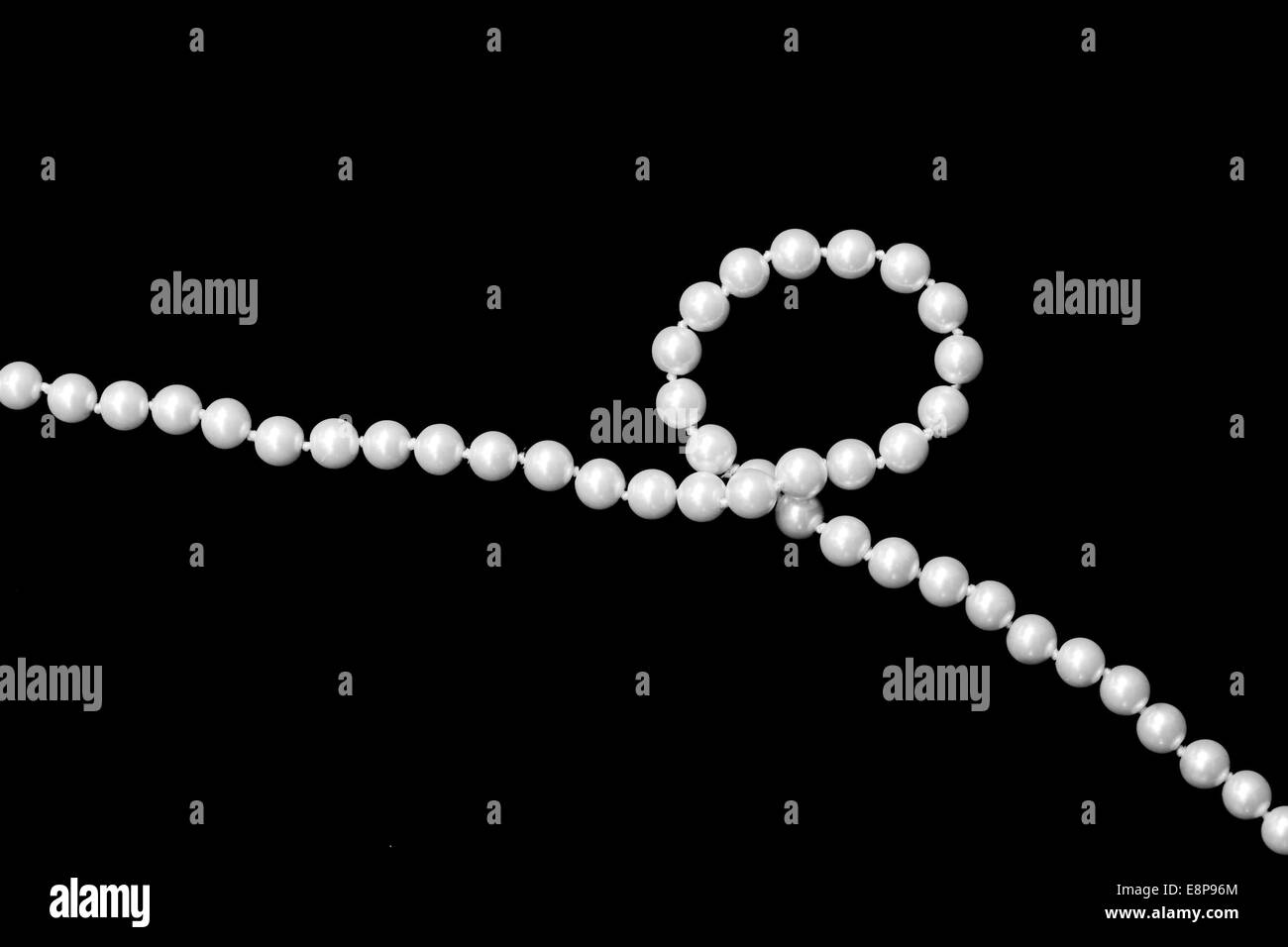 Filo di Perle di moda con anello singolo su sfondo nero Foto Stock