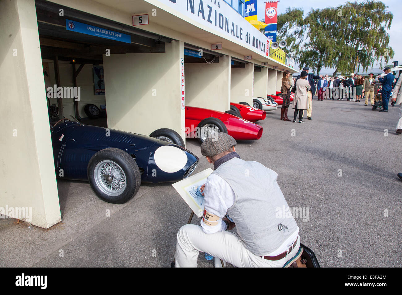 Artista il disegno di una visualizzazione di classic vintage racing Maserati automobili in una fossa scena al Goodwood 2014, West Sussex, Regno Unito Foto Stock