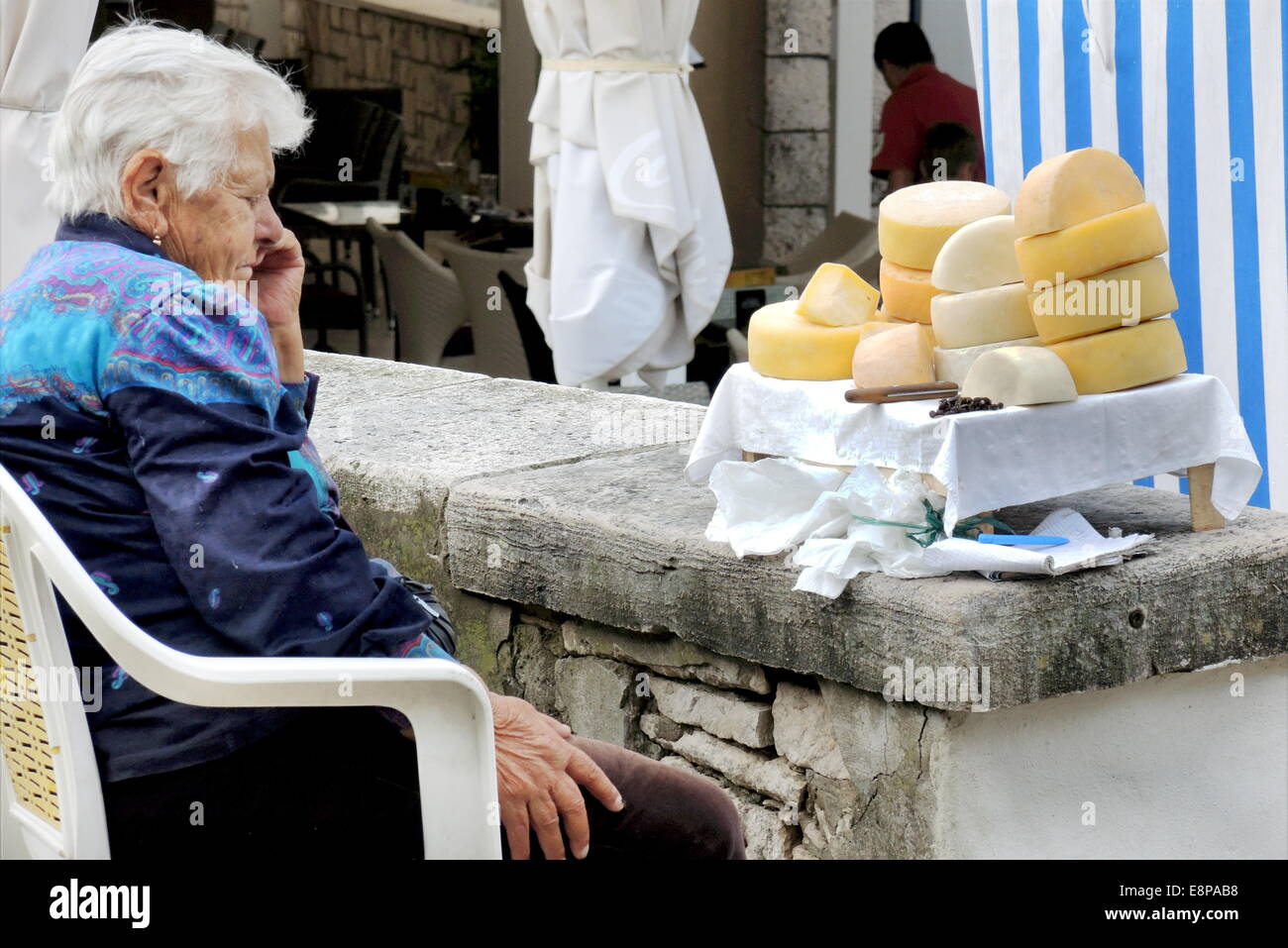 Off livellato, un venditore di self-made formaggio è seduto di fronte a lei di offrire su Spetember, 21, 2014, su un posto nella vecchia città di Korcula (Croazia) Foto Stock