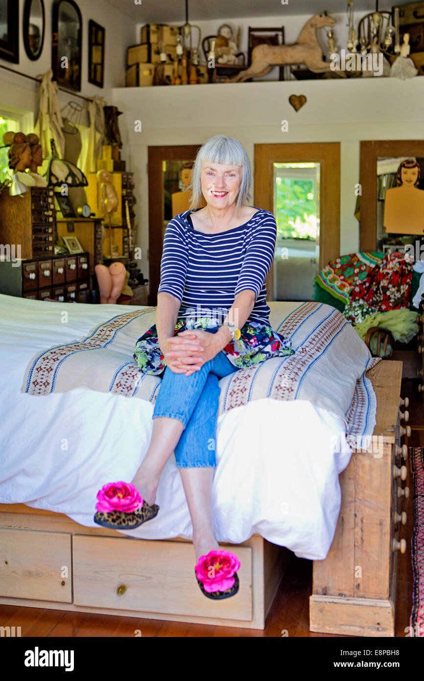 Senior donna seduta sul letto Foto Stock