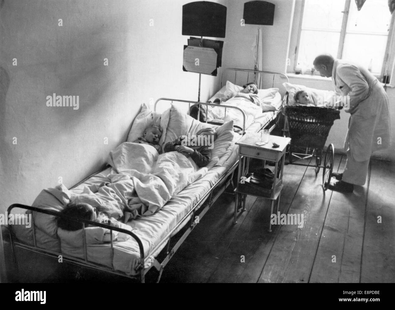 Una vista in un Sudeti ospedale tedesco in ceco Elbogen (Looket) nel maggio 1938. La foto è stata utilizzata dai nazisti a mostra le cattive condizioni di vita dei tedeschi dei Sudeti in Cecoslovacchia. Il nazista news service scrive sul retro dell'immagine: "Ci accusano! (Visita con tedeschi dei Sudeti.) l'ospedale in Elbogen. Il "isolamento caserma" dall'interno! La foto è stata scattata in un momento in cui l'ospedale fu sparsamente occupato. In caso contrario, 4 bambini si trovano in ogni letto, mescolati insieme da varie famiglie con varie malattie infettive. Scarlattina, il morbillo, la difterite. Il tutto sotto una coperta. N. Foto Stock