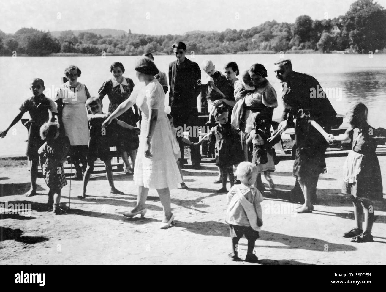 La foto della propaganda nazista mostra i rifugiati Volksdeutsche dalla Polonia in un campo profughi a Buckow, Germania, agosto 1939. Il testo originale del notiziario nazista sul retro della foto recita: 'Salvato dal terrore polacco - Volksdeutsche nel campo profughi di Buckow. I tedeschi rimangono temporaneamente nel campo profughi di Buckow fino a quando non ricevono nuovi alloggi. Mentre gli adulti si scambiano le loro storie, i bambini ballano e giocano.' Fotoarchiv für Zeitgeschichtee - NESSUN SERVIZIO DI CABLAGGIO Foto Stock