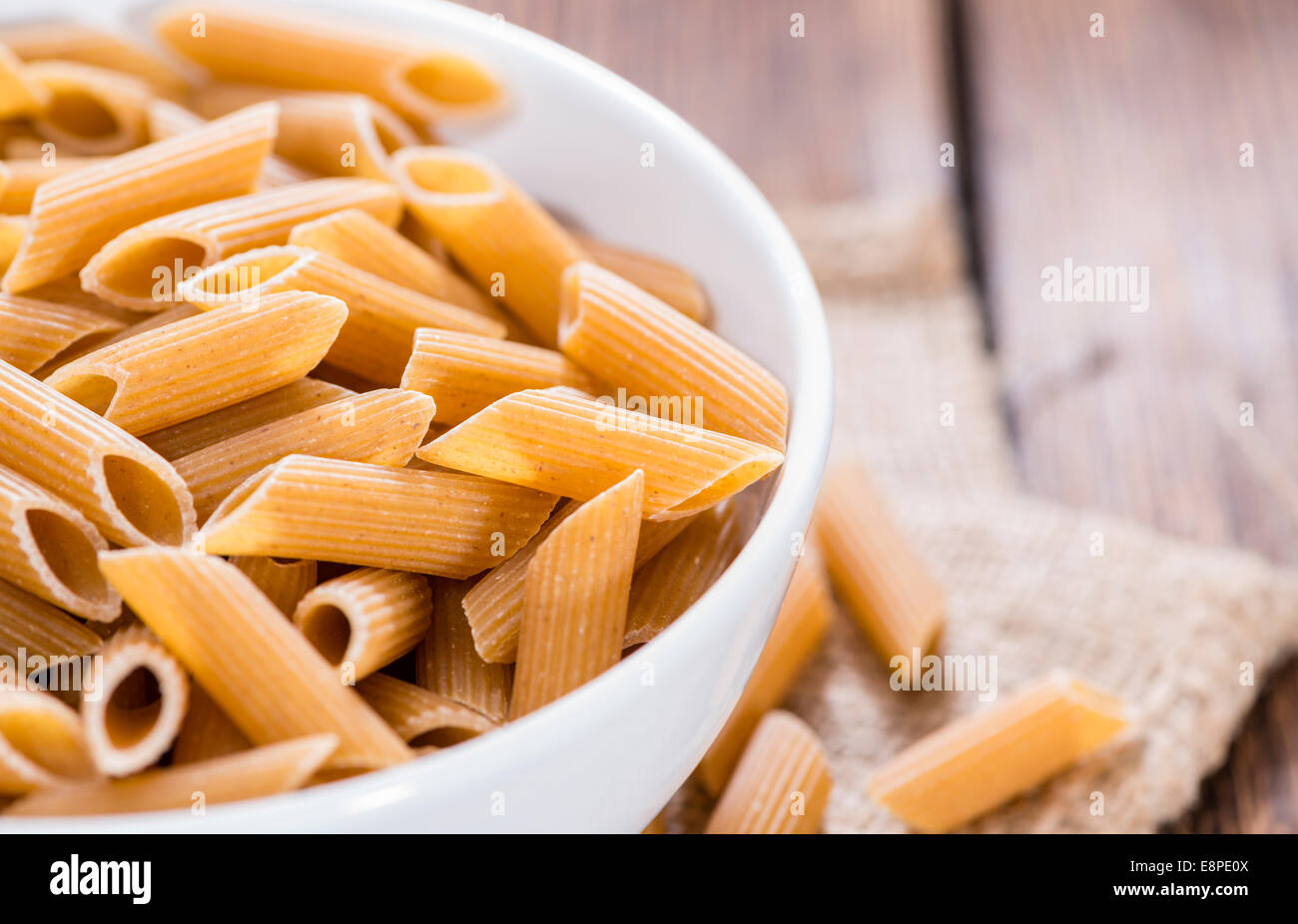 Freschi di penne integrali su un vecchio tavolo in legno Foto Stock