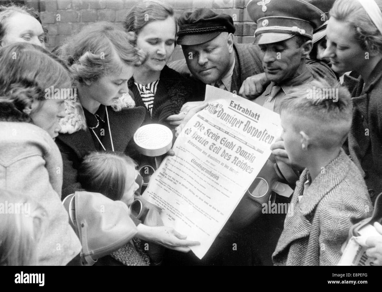 La foto della propaganda nazista mostra agli uomini, alle donne e ai bambini di leggere una pagina extra del giornale nazista "Danziger Vorposten" dal titolo "la città libera di Danzig fa parte del Reich Starting Today" a Danzig, Polonia, 01 settembre 1939. Dopo l'attacco illegale contro la Polonia da parte della Germania nel settembre 01, 1939, Danzig si unì al terzo Reich lo stesso giorno. Fotoarchiv für Zeitgeschichtee - NESSUN SERVIZIO DI CABLAGGIO Foto Stock