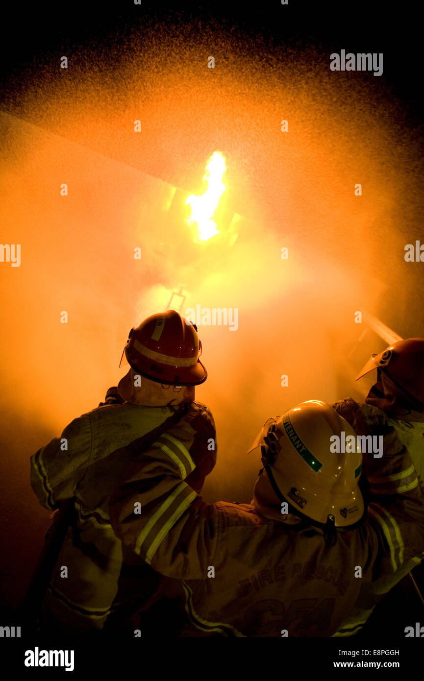 Attacco di vigili del fuoco di un caminetto a gas Foto Stock