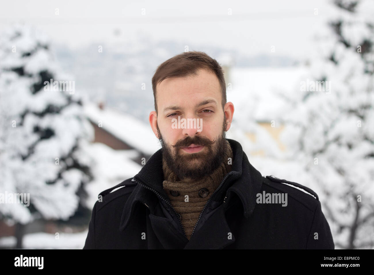 Ritratto di un giovane uomo in inverno solleva un sopracciglio Foto Stock