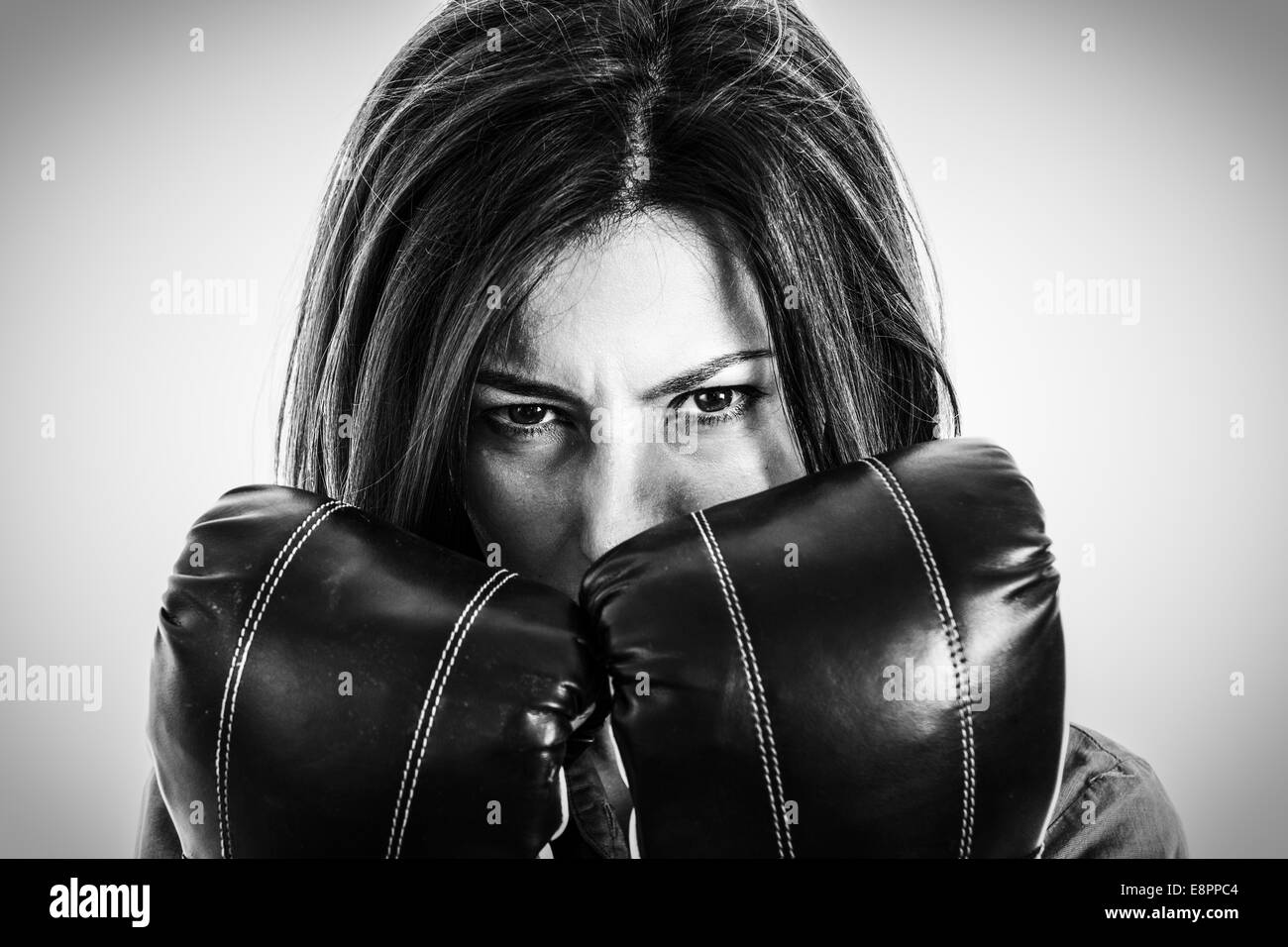 Closeup ritratto di una determinata boxer femmina. Fiducioso, intrepido e furiosa moderno business donna con i guantoni in isola Foto Stock