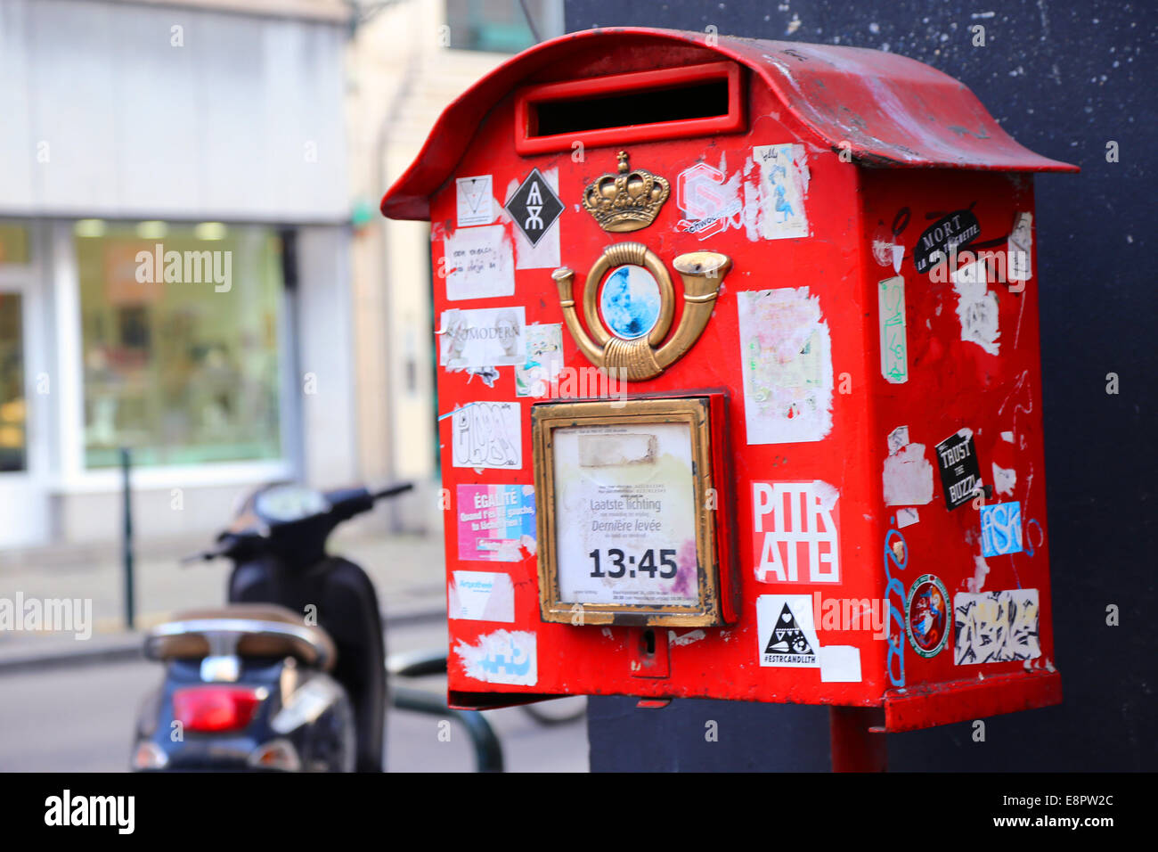 Postbox rosso a Bruxelles. Scooter in background. Foto Stock