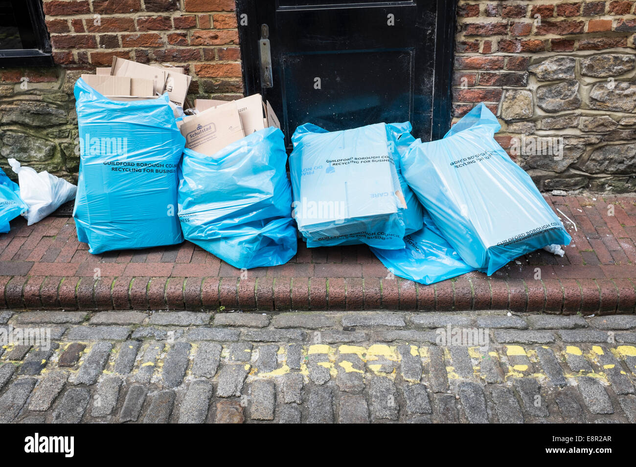 Rifiuti di carta blu in sacchetti di plastica posto sulla soglia di un ufficio in attesa di raccolta per il riutilizzo di. Foto Stock