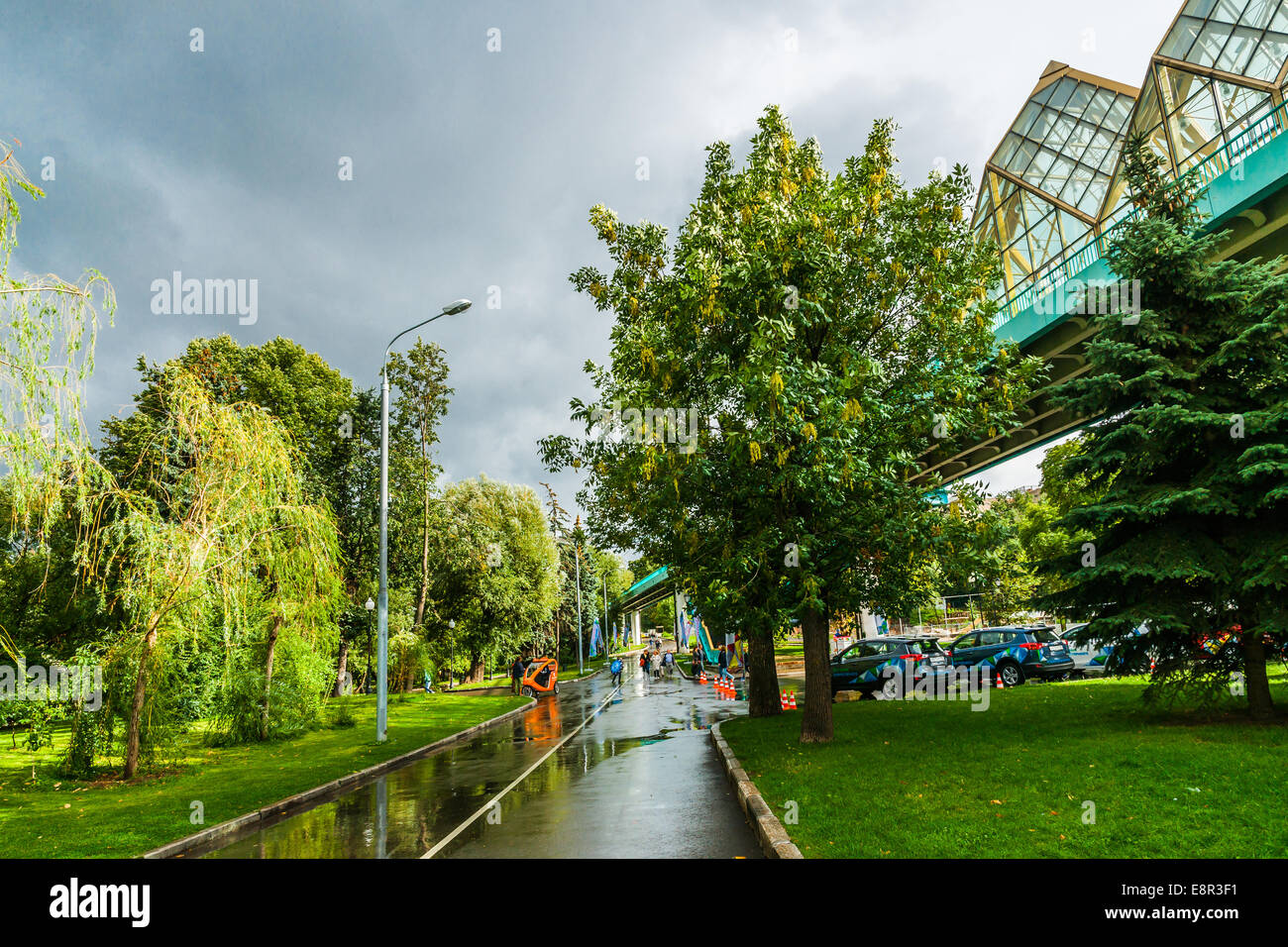Mosca, Russia. 30 Agosto 2014: Vicolo di Mosca Gorky Park dopo la pioggia. Andreevsky ponte pedonale oltre il fiume di Mosca Foto Stock