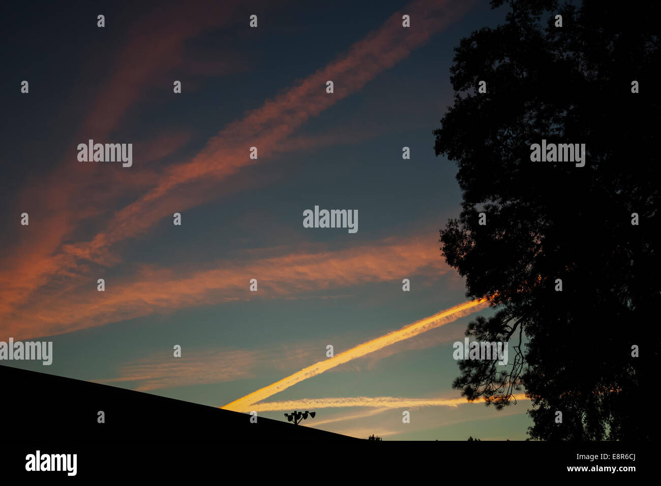 Jet contrails sono colorate al tramonto in North Florida. Foto Stock