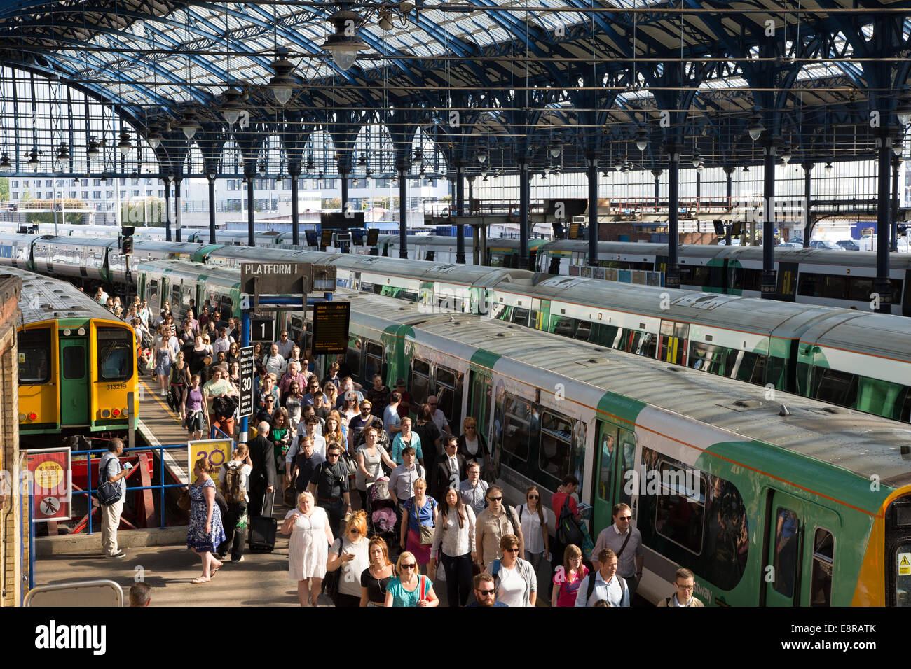 I passeggeri di scendere dal treno e a piedi verso i cancelli del biglietto presso la stazione del treno durante una trafficata mattina d'estate. Il passeggero Foto Stock