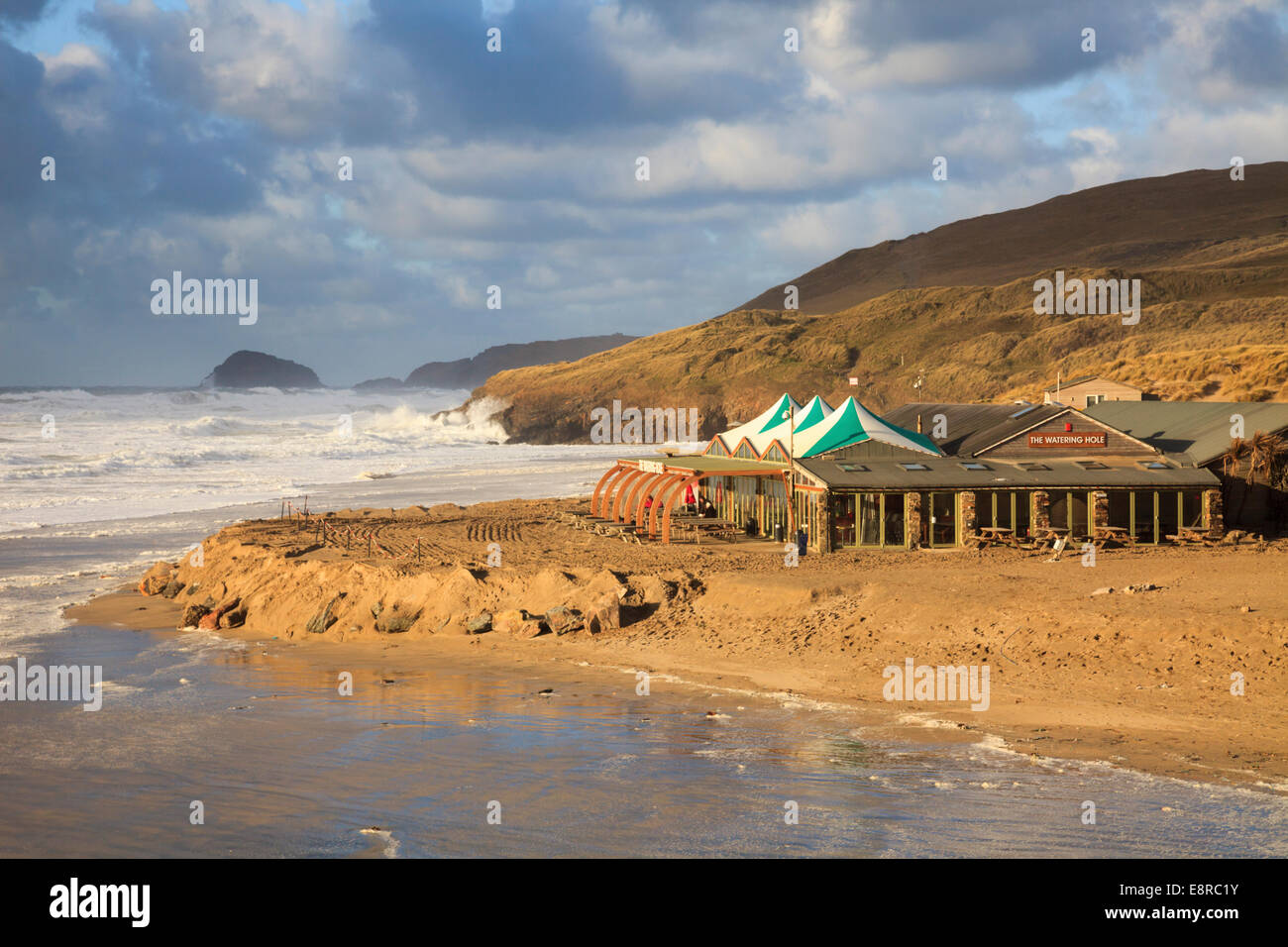 Il Watering Hole public house sulla spiaggia a Perranporth in Cornovaglia. Catturato ad alta marea su un burrascoso inverni di pomeriggio. Foto Stock