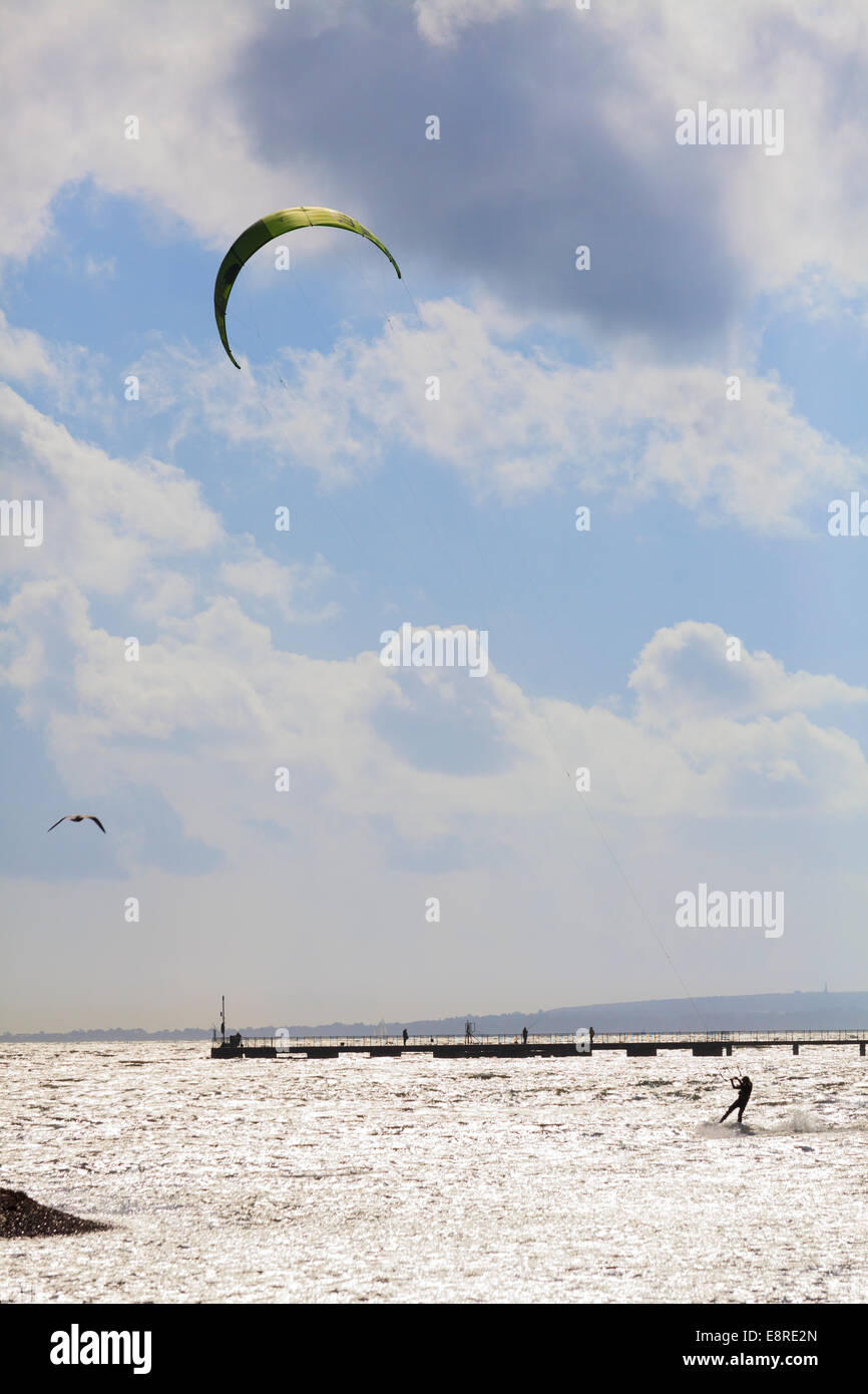Persona kitesurf a Porto sui semi silhouette contro un mare scintillante. Foto Stock