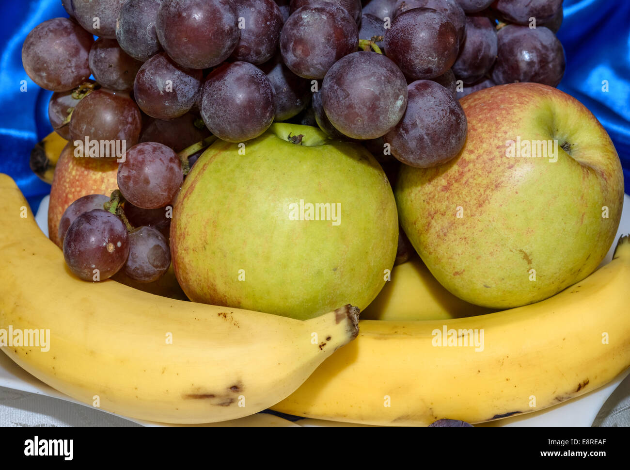 Apple, banana e uva, su una piastra per il deserto Foto Stock