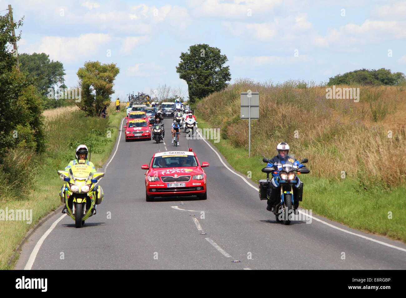 La testa del Tour de France 2014 convoglio si avvicina Saffron Walden, Essex, Regno Unito, durante la fase 3 della gara. Foto Stock