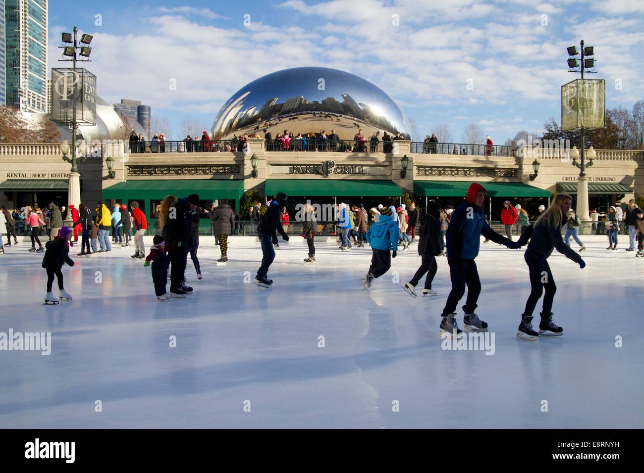Pattinaggio sul ghiaccio pattino il McCormick Tribune pista di pattinaggio su ghiaccio, Cloud Gate scultura in background. Il Millennium Park di Chicago, Illinois. Foto Stock