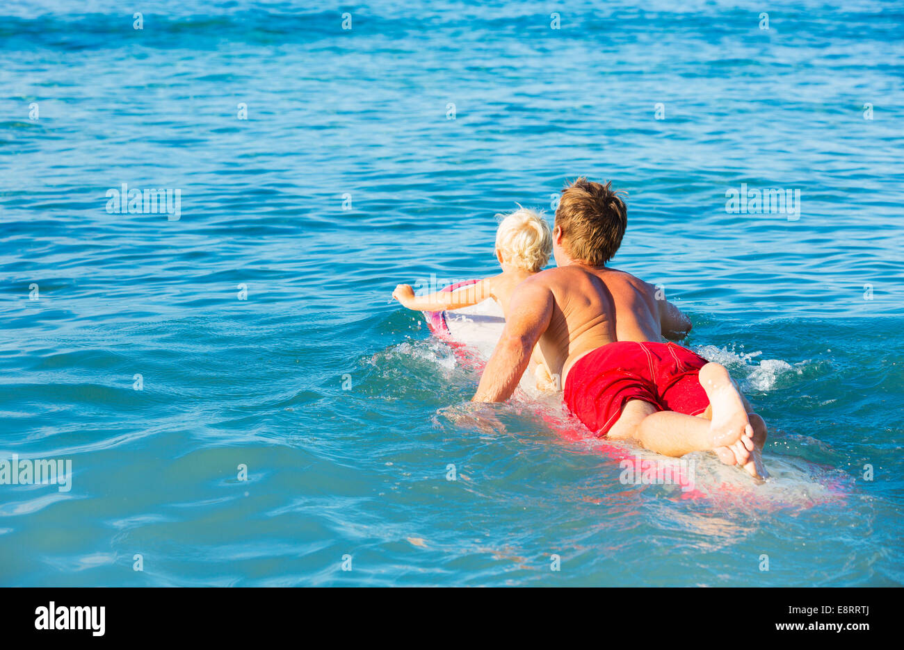 Felice padre e figlio giovane andando surfare insieme Foto Stock