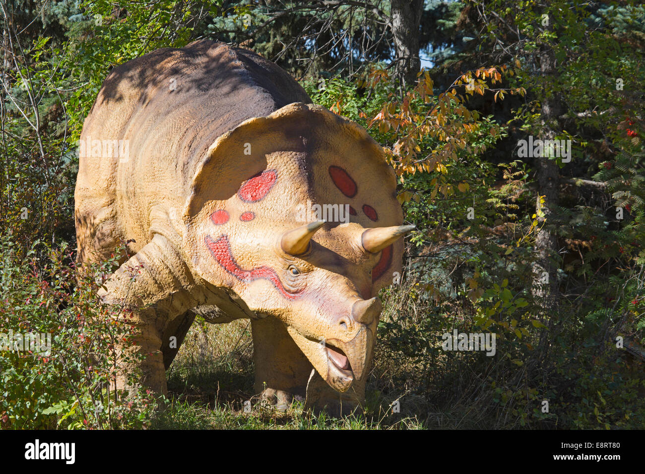 Modello di dinosauro che emerge dalla foresta nel parco preistorico dello zoo di Calgary Foto Stock