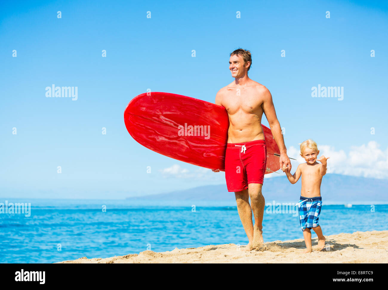 Padre e Figlio andando surf in spiaggia Foto Stock