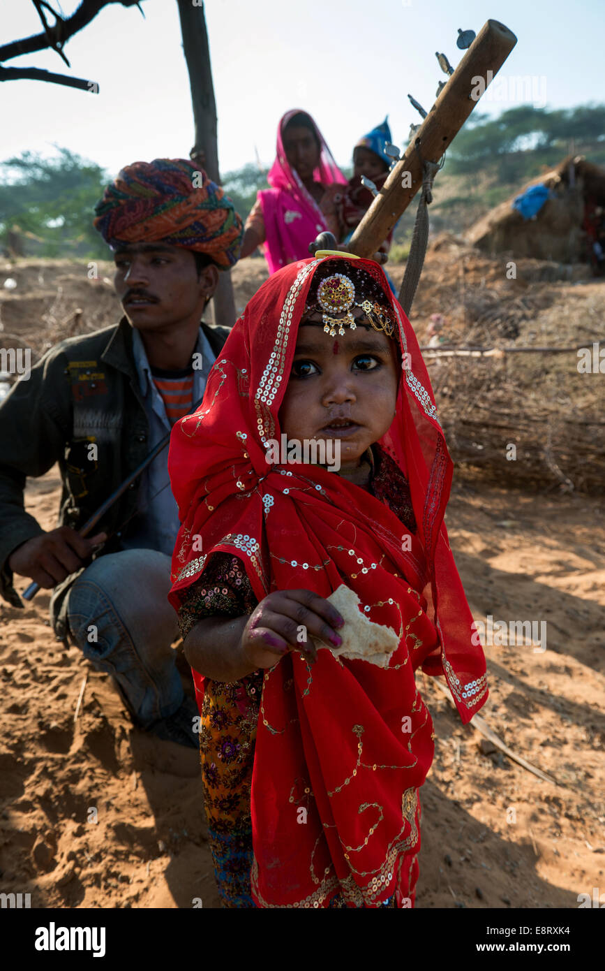 Una bambina con il suo genitore in tradizionali abiti indiani.Pushkar, Rajasthan,l'India. Foto Stock