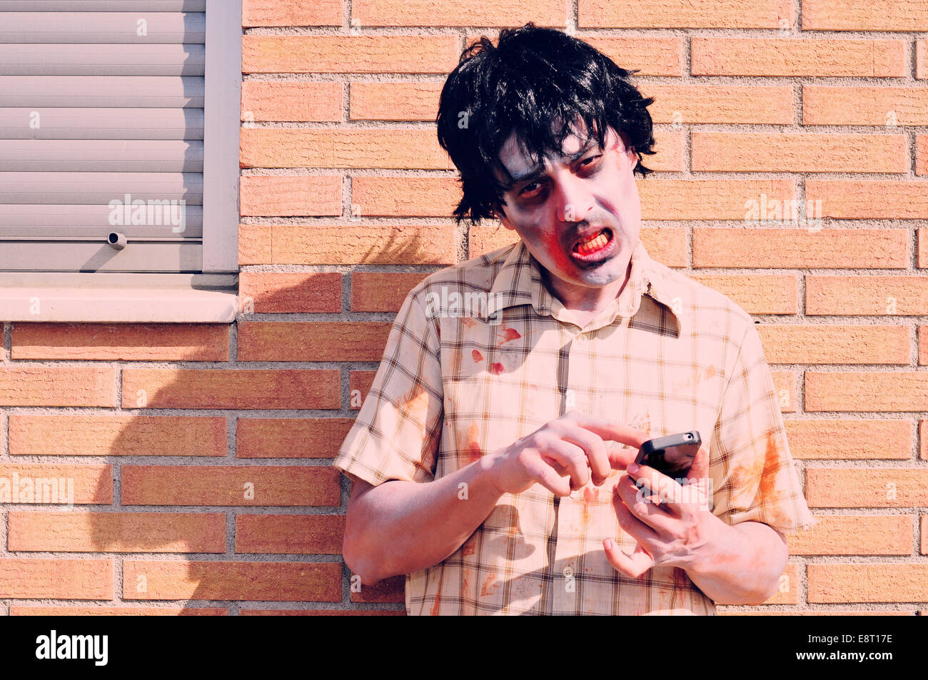 Un pauroso zombie utilizzando uno smartphone Foto Stock