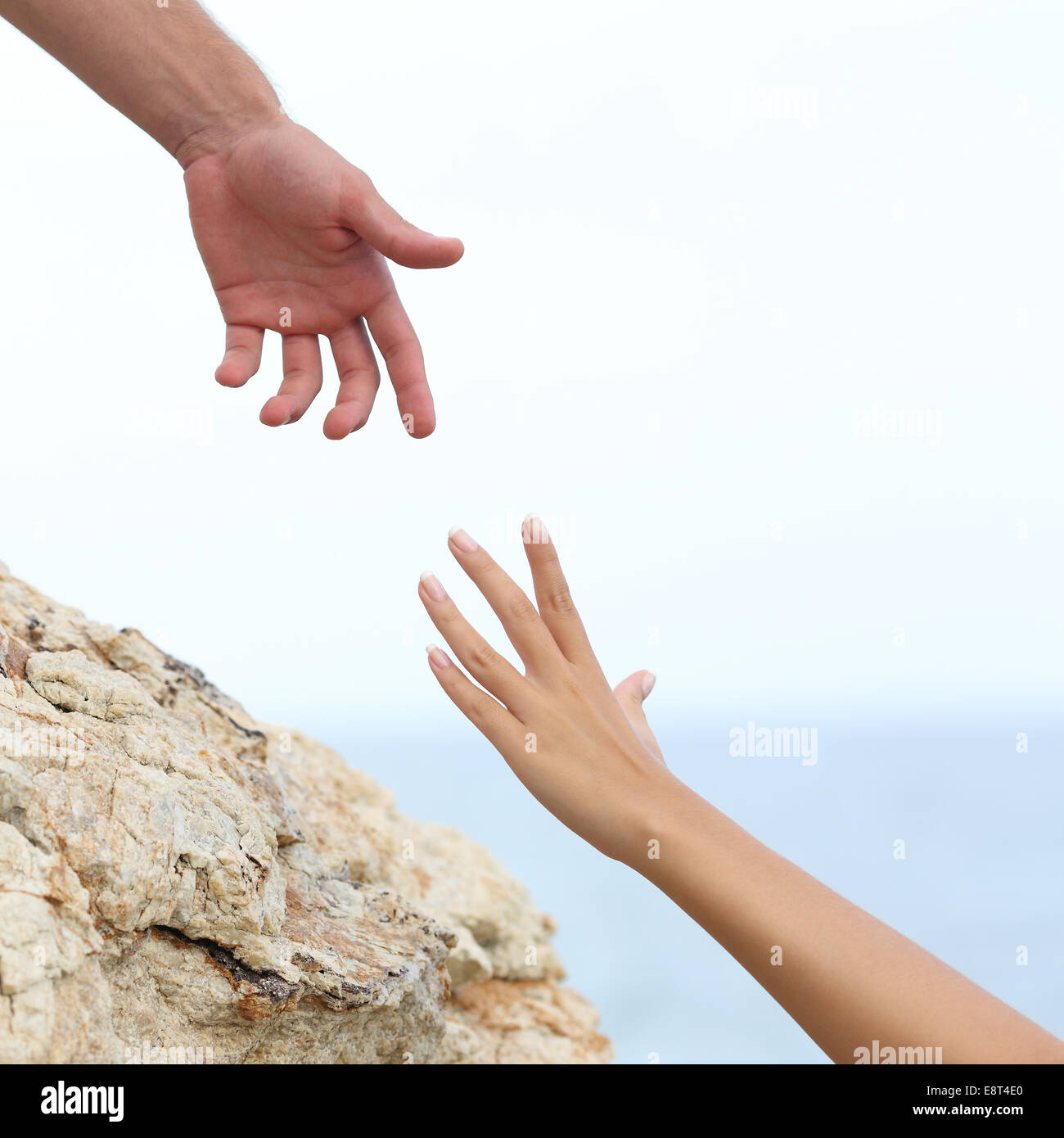 L uomo e la donna mani aiutando concetto con il mare in background Foto Stock
