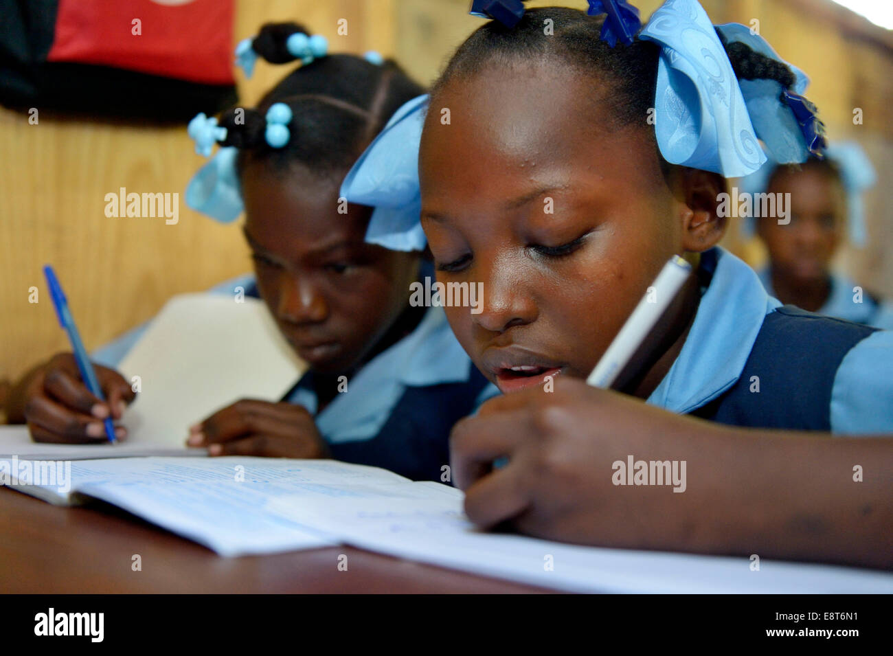 Due ragazze iscritto in un notebook, scuola per rifugiati di terremoto, Fort National, Port-au-Prince, Haiti Foto Stock