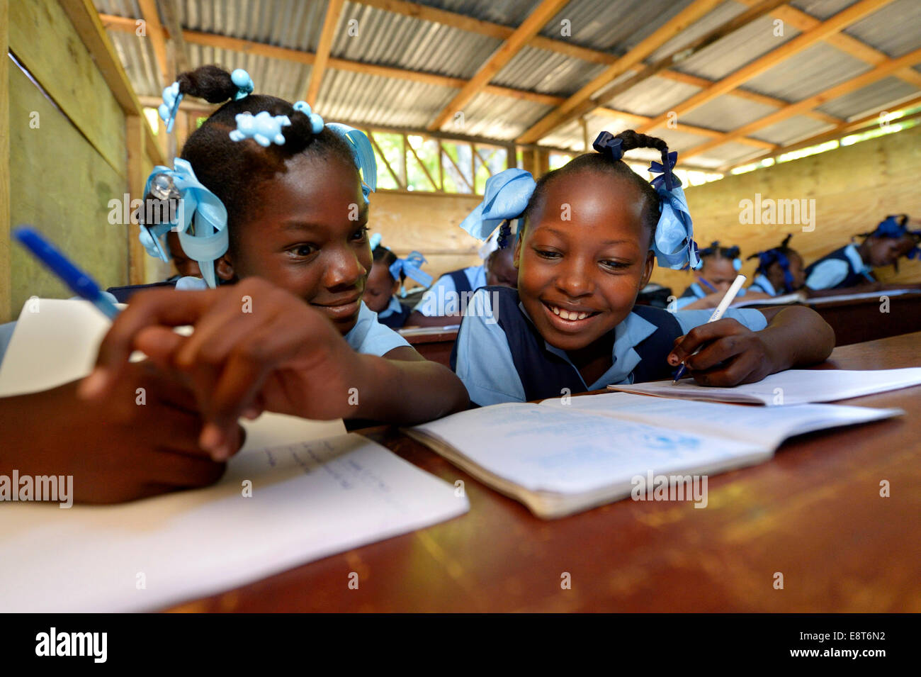 Due ragazze iscritto in un notebook, scuola per rifugiati di terremoto, Fort National, Port-au-Prince, Haiti Foto Stock