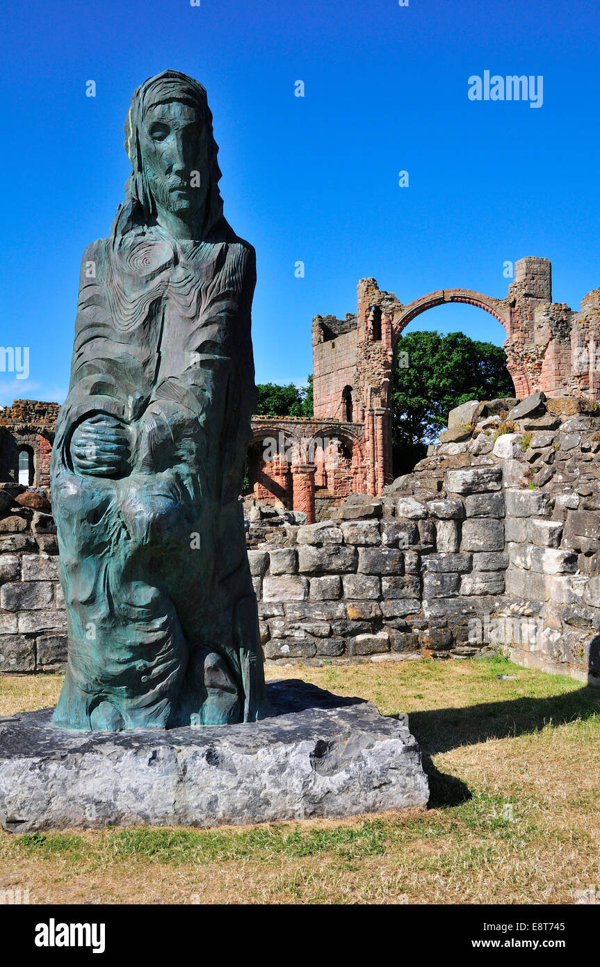 Statua di San Cutberto di Lindisfarne e le rovine del monastero benedettino di Lindisfarne, Lindisfarne in Northumbria, Inghilterra Foto Stock