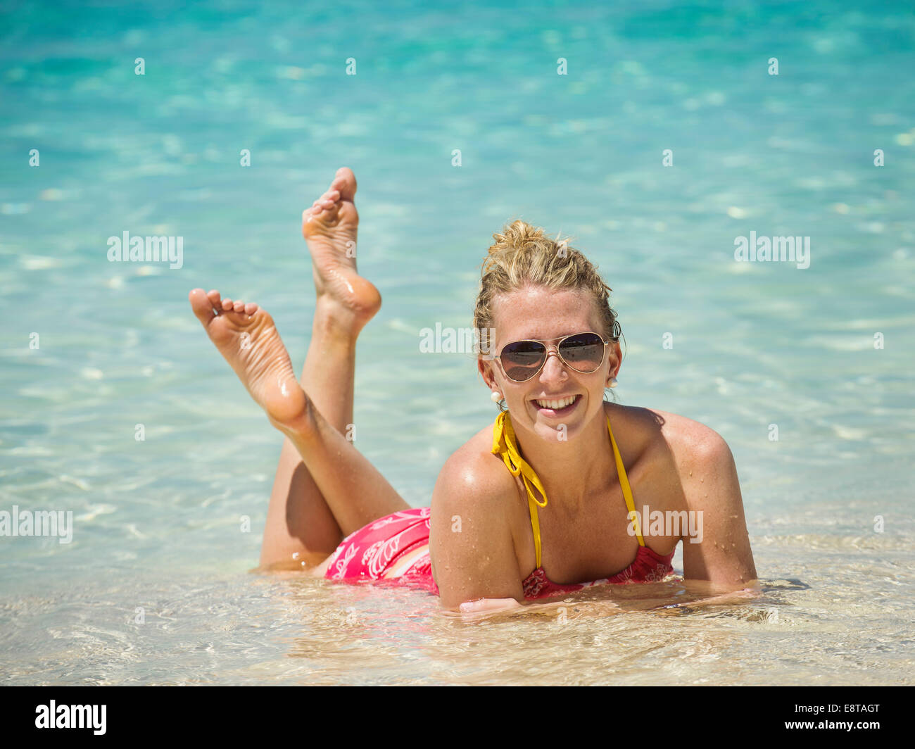 La donna caucasica la posa in acqua in oceano tropicale Foto Stock