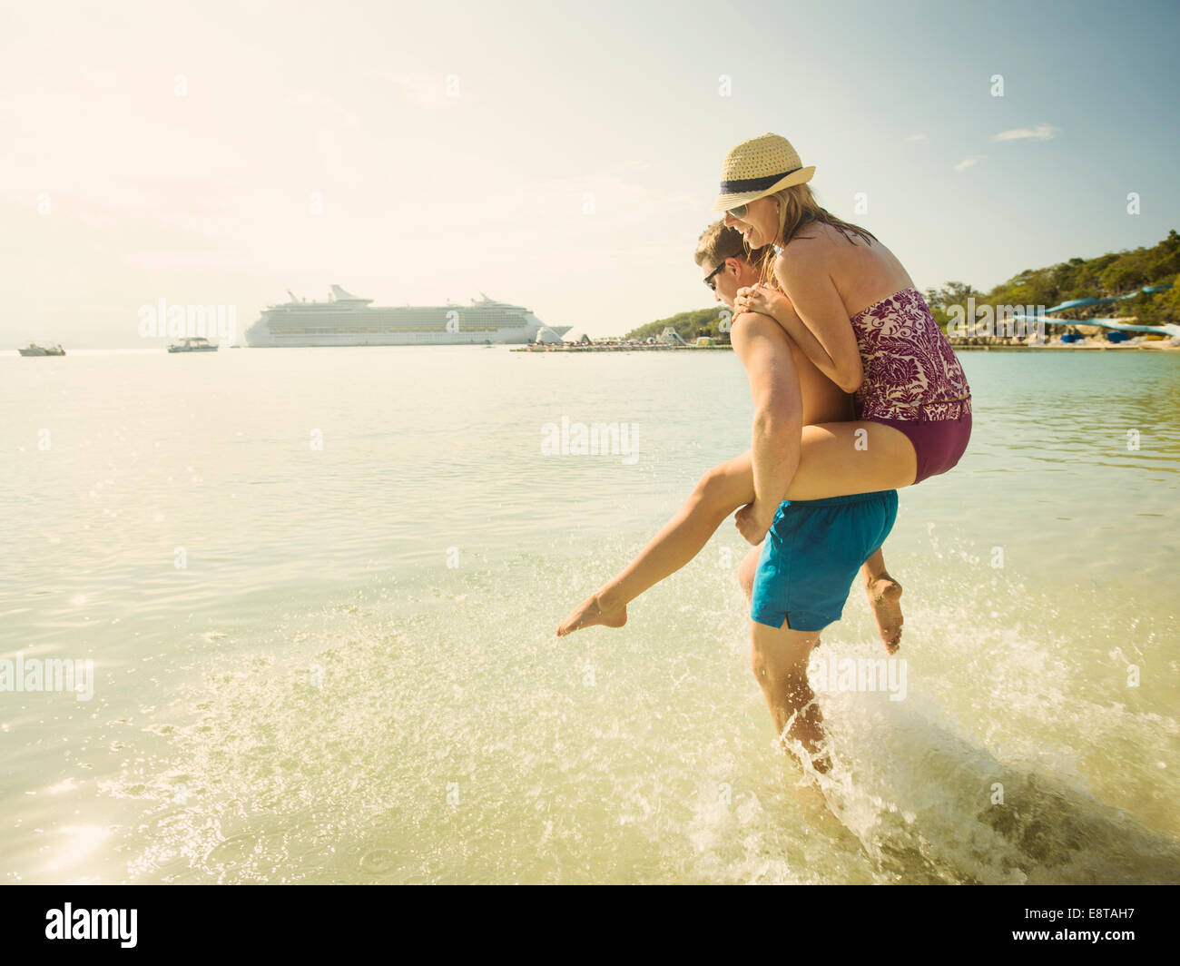 Coppia caucasica giocando in oceano tropicale Foto Stock