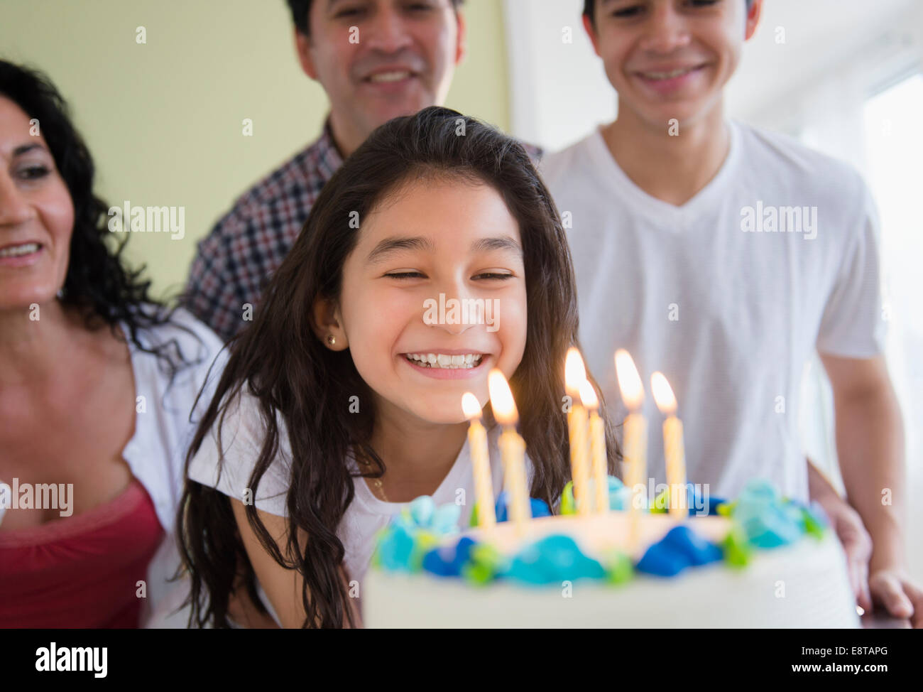 Ragazza ispanica ammirando la torta di compleanno Foto Stock