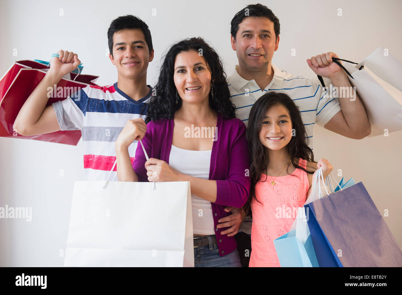 Famiglia di origine ispanica holding shopping bags insieme Foto Stock