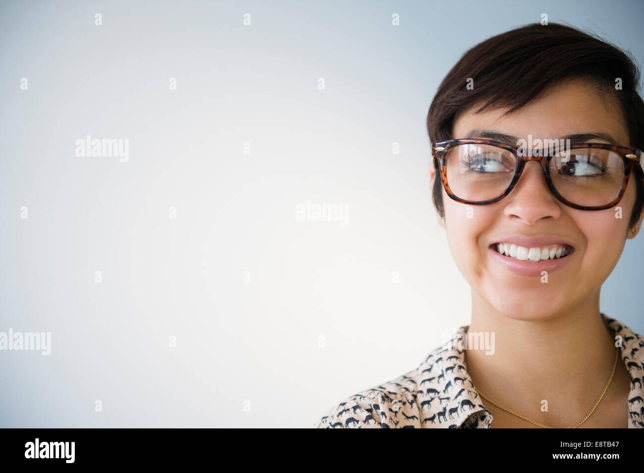 Sorridente razza mista donna che indossa occhiali Foto Stock