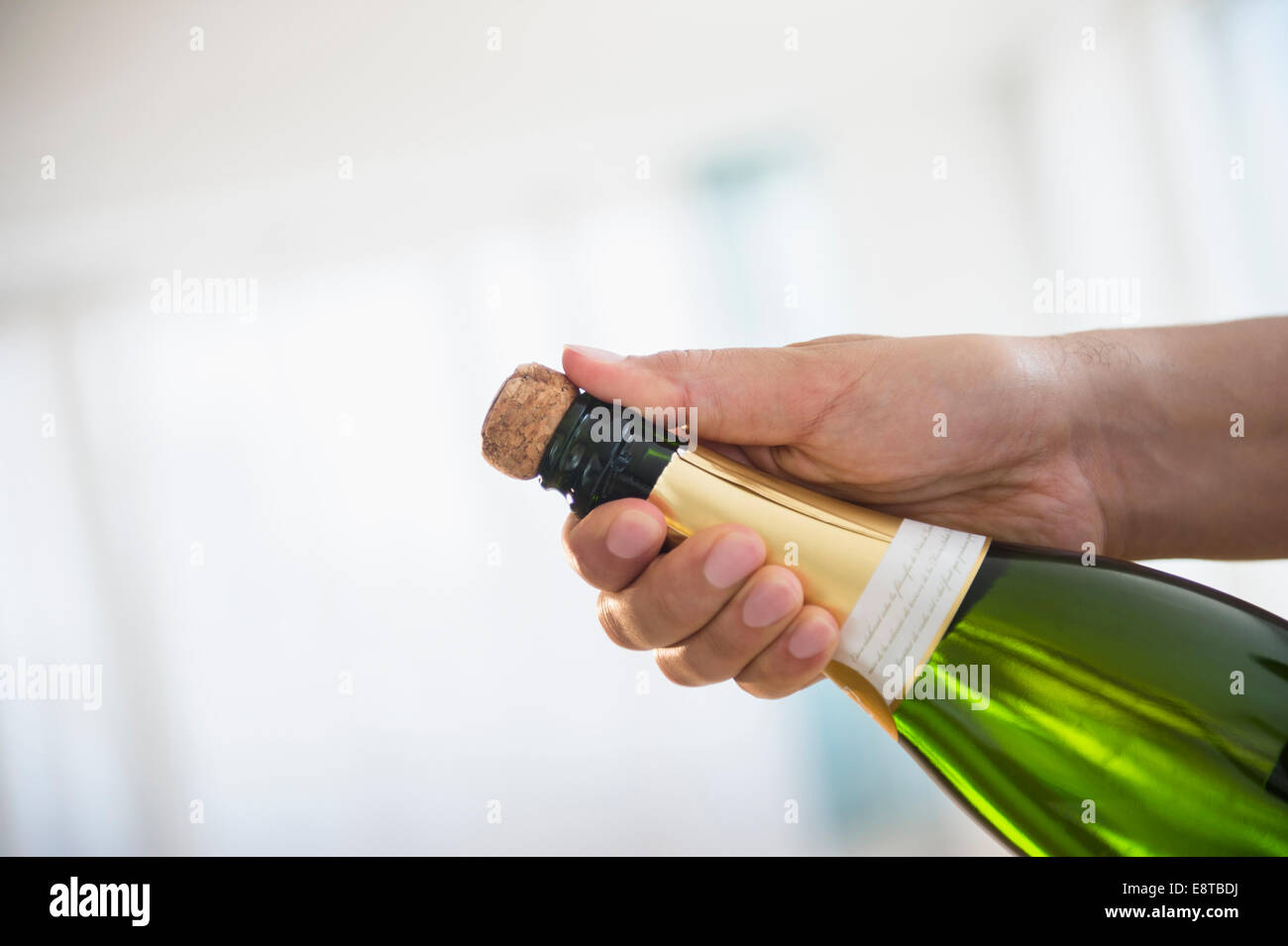 Close up di razza mista uomo apertura della bottiglia di champagne Foto Stock