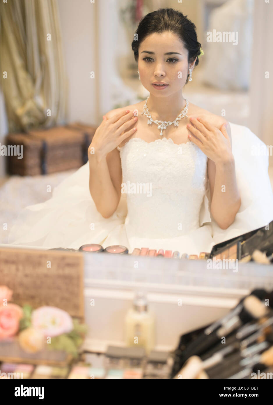 Razza mista, Asian / American sposa in bianco abito da sposa la preparazione per il suo matrimonio, controllo trucco e capelli. Foto Stock
