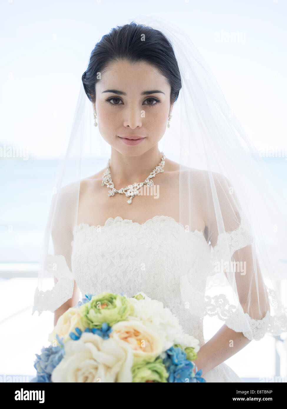 Razza mista, Asian / American sposa in bianco abito da sposa in spiaggia tropicale di nozze di destinazione Foto Stock