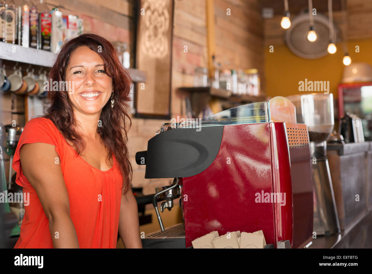Sorridente ragazza ispanica lavorando in coffee shop Foto Stock