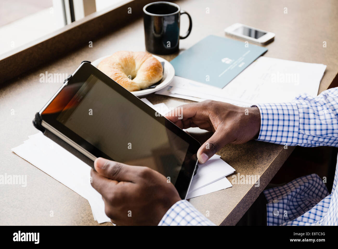 Imprenditore nero utilizzando digitale compressa in cafe Foto Stock
