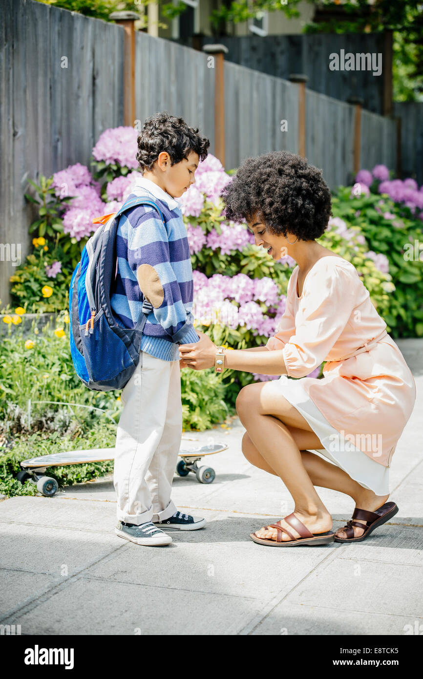 Razza mista madre figli tenendo le mani sul marciapiede suburbana Foto Stock