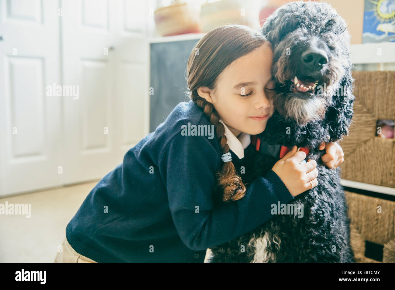 Razza mista ragazza abbracciando il cane Foto Stock