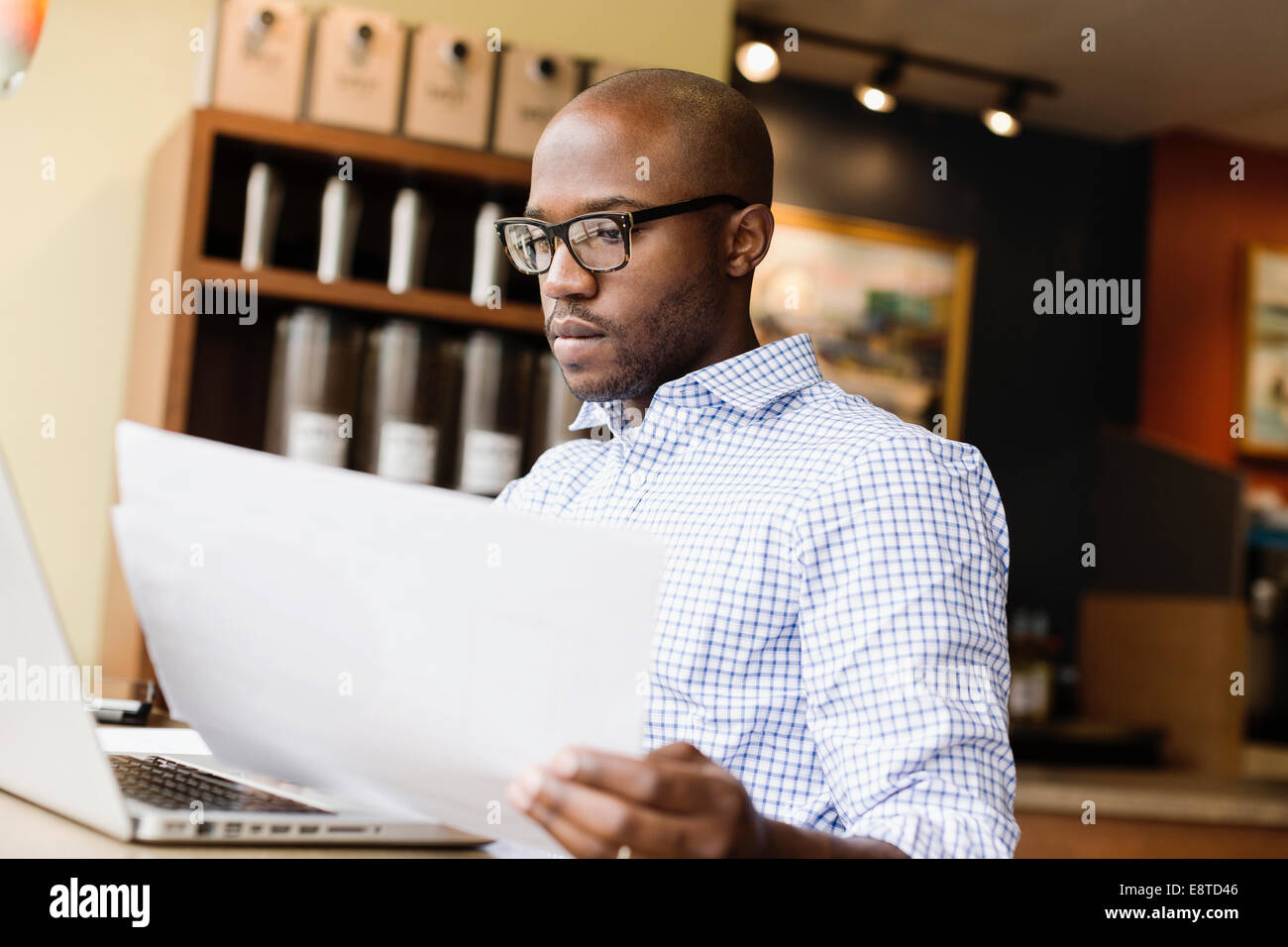 Uomo nero utilizzando laptop in coffee shop Foto Stock