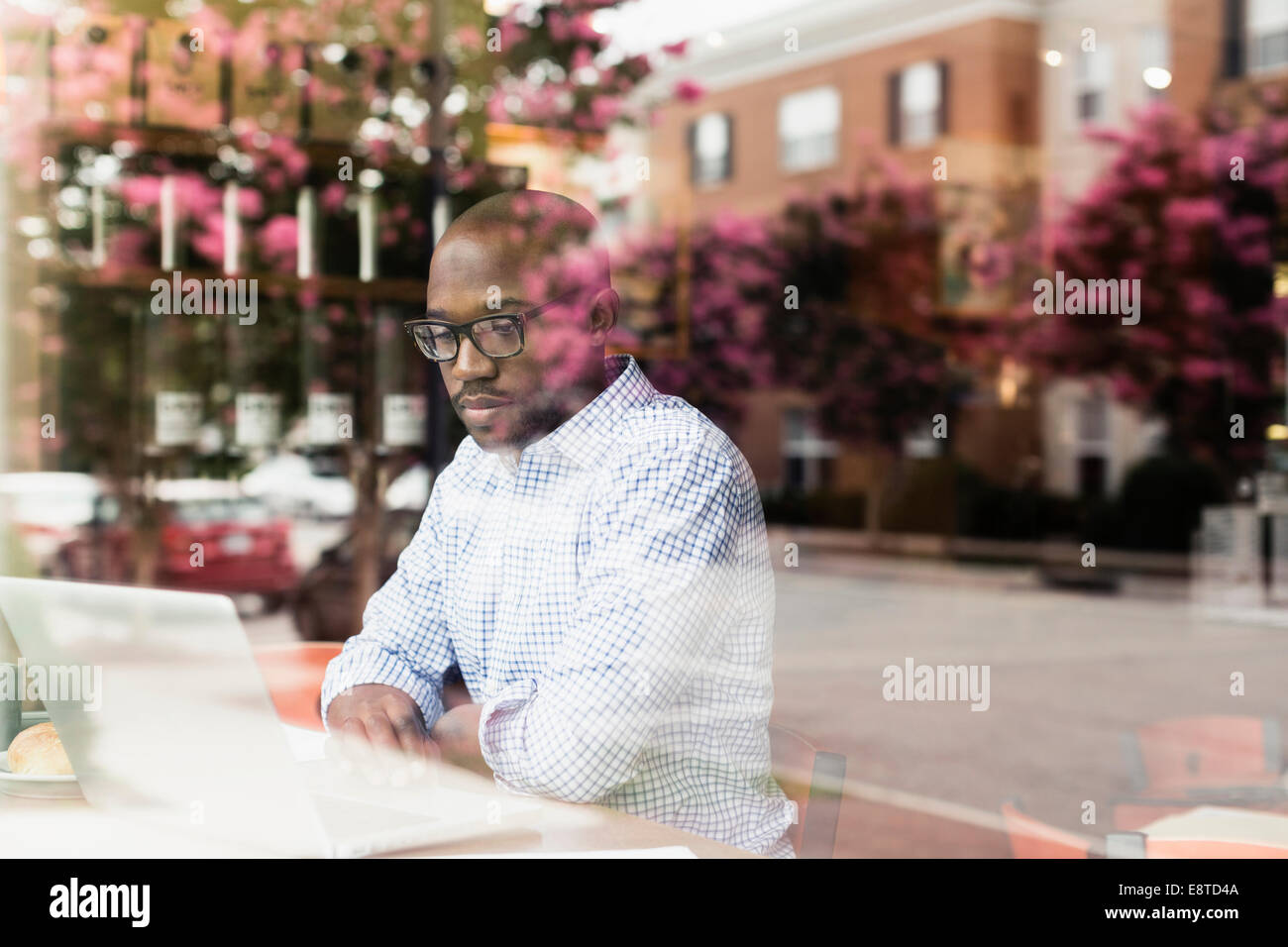 Uomo nero utilizzando laptop in coffee shop Foto Stock