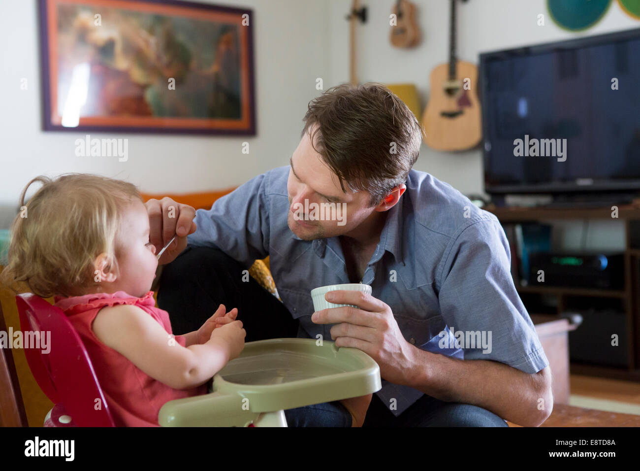 Padre caucasica alimentazione figlia toddler Foto Stock