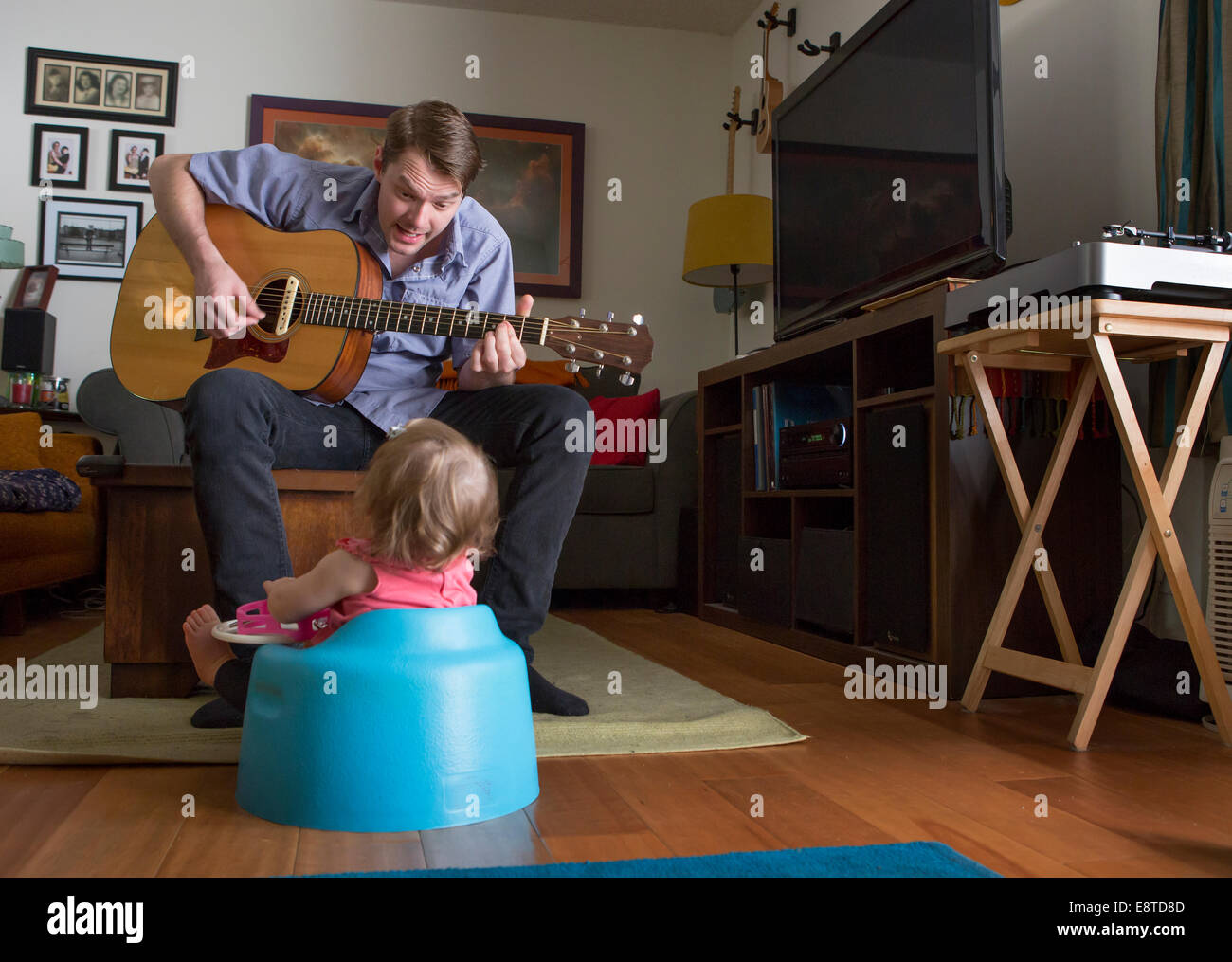 Padre caucasica a suonare la chitarra per la figlia di Foto Stock