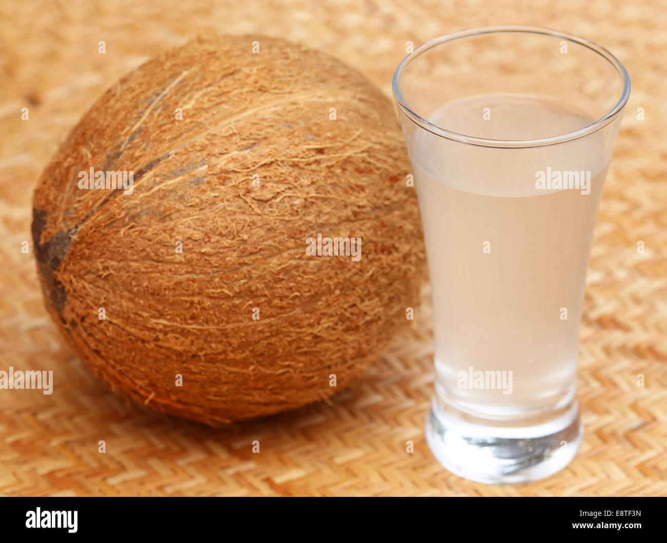 Cocco fresco con acqua in un bicchiere sulla superficie testurizzata Foto Stock